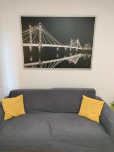 un sofá con 2 almohadas amarillas en la sala de estar en Apartaments Puigcardener 1, en Manresa