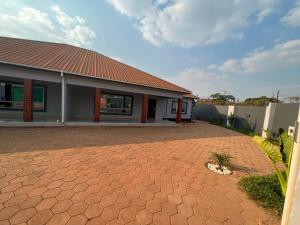 a house with a brick driveway in front of it at Lemajy Apartments in Solwezi