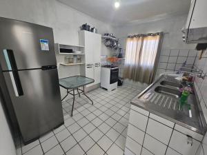 a kitchen with a stainless steel refrigerator and a table at Cobertura no Pina in Recife