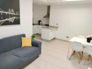 uma sala de estar com um sofá azul e uma mesa em Apartaments Puigcardener 1 em Manresa