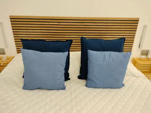 a bed with two blue pillows on it at Apartaments Puigcardener 1 in Manresa
