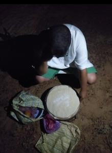 a young boy bending down to look at a bowl at النخلة in Erfoud