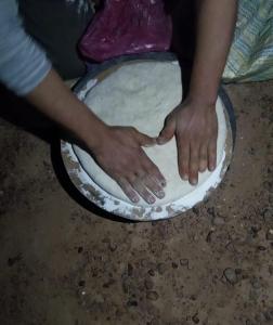 een persoon maakt een deeg in een pan bij النخلة in Erfoud