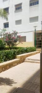 un trottoir devant un grand bâtiment blanc dans l'établissement Begoniâ house, à Agadir