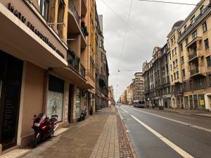 an empty city street with a motorcycle parked on the sidewalk at Stylish studio in the heart of Riga in Rīga