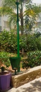 un poteau vert dans un jardin planté d'arbres et de buissons dans l'établissement Begoniâ house, à Agadir