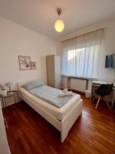 1 dormitorio con cama, escritorio y ventana en Hotel Breuer, en Hamm