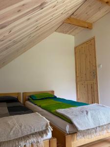 a bedroom with a bed and a wooden ceiling at Agroturystyka Łazory nad Tanwią 
