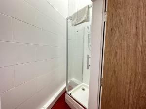 a shower with a glass door in a bathroom at Chic Downtown Flat in Dudley Near Attractions in Birmingham