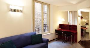a living room with a blue couch and a table at Un Gioiello sotto le Due Torri in Bologna