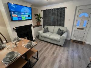 a living room with a table and a couch and a television at Central Brentwood House in Brentwood