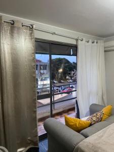 un salon avec un canapé et une grande fenêtre dans l'établissement LOFT Adorável no coração de BsB, à Brasilia