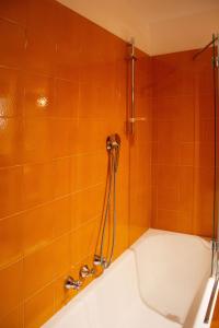 a bath tub in a bathroom with orange tiles at Un Gioiello sotto le Due Torri in Bologna