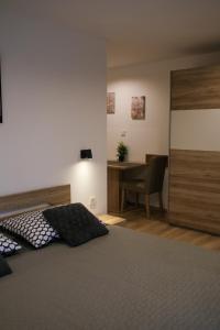 ein Schlafzimmer mit einem Bett und einem Schreibtisch mit einem Stuhl in der Unterkunft Apartments Vukalovic in Medulin