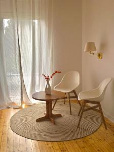 une chambre avec une table, deux chaises et un vase dans l'établissement Hotel Breuer, à Hamm