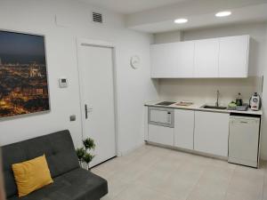 a living room with a couch and a kitchen at Apartaments Puigcardener BX in Manresa