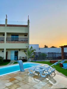 a villa with a swimming pool and a house at Pousada Delta Village in Tutóia