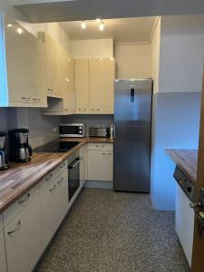 a kitchen with white cabinets and a stainless steel refrigerator at Haus Paznaun in Kappl