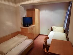 Cette petite chambre comprend 2 lits et une télévision. dans l'établissement Haus Paznaun, à Kappl