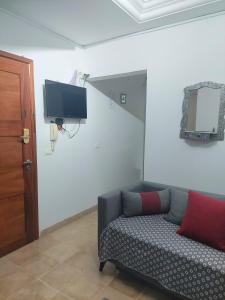 a living room with a couch and a tv on the wall at Appartement S1 Jardins l aouina in Tunis