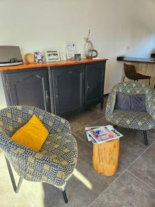 ein Wohnzimmer mit 2 Stühlen und einem Tisch in der Unterkunft Loft & spa d'Autan in Villefranche-de-Lauragais