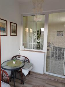 a dining room with a table and a glass window at Apartman Stanimirović 3 in Zaječar