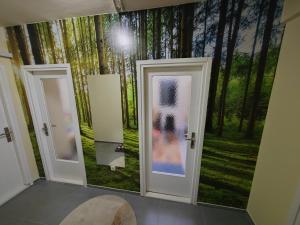 a room with two doors and a forest mural at Apartman Stanimirović 3 in Zaječar