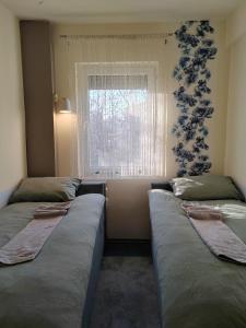 2 camas en una habitación con ventana en Apartman Stanimirović, en Zajecar