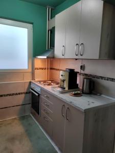 a kitchen with white cabinets and a counter top at Apartman Stanimirović 3 in Zaječar