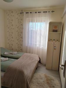 1 dormitorio con 2 camas y ventana en Apartman Stanimirović, en Zajecar