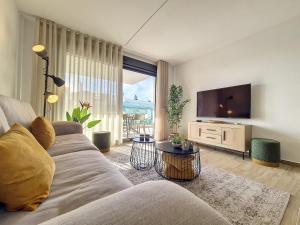 a living room with a couch and a flat screen tv at Los Alcazares Velapi - 0810 in San Javier