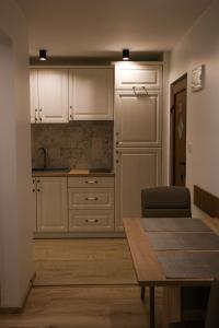 eine Küche mit weißen Schränken und einem Holztisch in der Unterkunft Apartments Vukalovic in Medulin