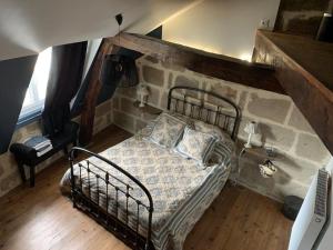 una camera con un letto e un muro in pietra di appartement de charme centre historique de Brive a Brive-la-Gaillarde