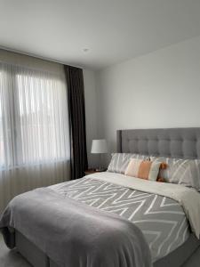 um quarto com uma cama grande e uma janela em Luxury one bedroom flat in Harrow em Harrow