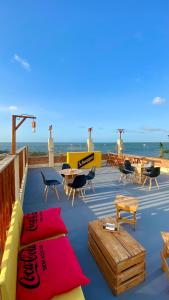 a patio with tables and chairs and the ocean at Pousada Delta Village in Tutóia