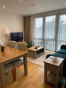 uma sala de estar com um sofá azul e uma mesa em Luxury one bedroom flat in Harrow em Harrow