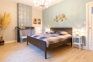 una camera con letto e lampadario a braccio di Sweet Alice Holiday Home a Ypres