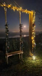 una panchina sotto un pergolato con luci di Casa Horizont a Slankamenački Vinogradi