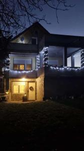 ein Haus mit Lichtern an der Vorderseite in der Nacht in der Unterkunft Casa Horizont in Slankamenački Vinogradi