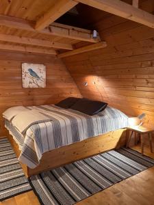 sypialnia z łóżkiem w drewnianym domku w obiekcie DZIUPLA - Berghaus in der Tatra mit Holzsauna w mieście Brzegi