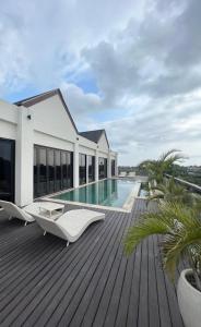 una terraza de madera con piscina en una casa en EL Suites Berawa - Canggu, en Canggu