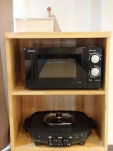 ラン島にあるHabor House by Koh Larn Rivieraの木製棚の黒い電子レンジ(黒い電化製品付)