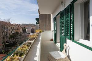 a balcony with green shutters and a bench on a building at Stylish Theatre Apartments in Split