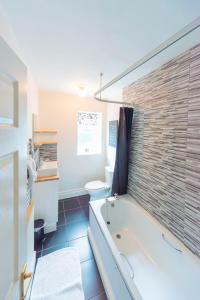 een badkamer met een bad, een toilet en een wastafel bij Hope Terrace in Matlock