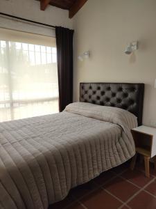 a bedroom with a bed with a large window at Solares de Tanti in Tanti Nuevo