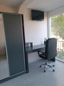 una oficina con escritorio, silla y ventana en Digital Nomads Apartments, en Bar