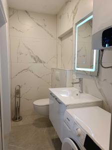 Digital Nomads Apartments في بار: حمام أبيض مع حوض ومرحاض