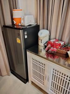 een keuken met een koelkast en een aanrecht met een tafel bij Habor House by Koh Larn Riviera in Ko Larn