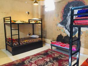 a room with two bunk beds and a rug at Jaisalmer hostel in Jaisalmer