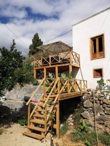 a building with a wooden deck next to a building at Souterrain für max 2 P., Bad, Außenküche, Garten in Güimar